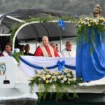 Entre a margem e o horizonte, a barca de Pedro atravessa o Lago Albano com Maria